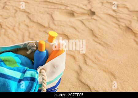 Bag with sunscreen cream on beach Stock Photo