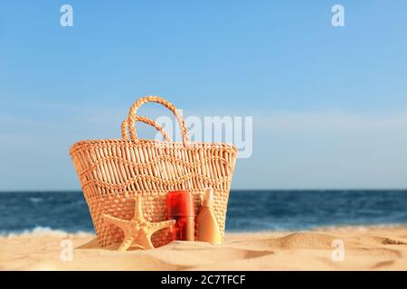 Bag with sunscreen cream on beach Stock Photo