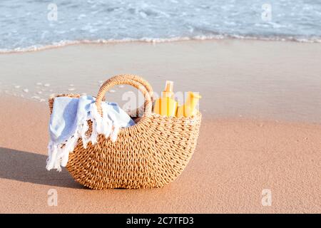 Bag with sunscreen cream on beach Stock Photo