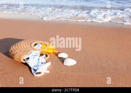 Bag with sunscreen cream on beach Stock Photo