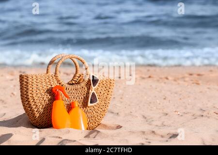 Bag with sunscreen cream on beach Stock Photo