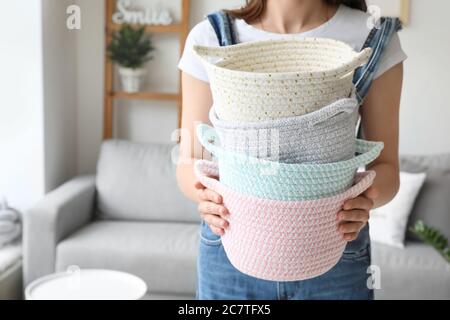 Woman holding wicker baskets in room Stock Photo