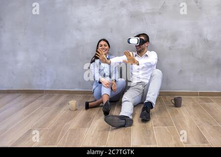 Young couple planning the arrangement of apartment using virtual reality headset Stock Photo