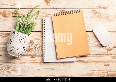 Notebooks with computer mouse and flowers on white wooden background Stock Photo