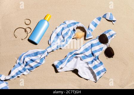 Beach accessories with sunscreen cream on sand Stock Photo