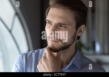 Pensive young caucasian man look in distance thinking Stock Photo