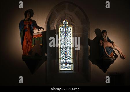 in the darkness of a small church. A place to pray and meditate Stock Photo