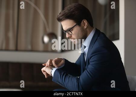 Serious businessman look at hand watch checking time Stock Photo