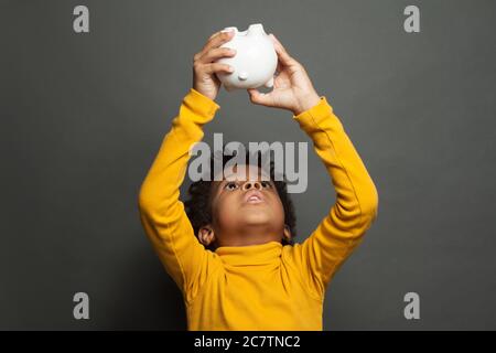 African American kid boy with empty piggy bank Stock Photo