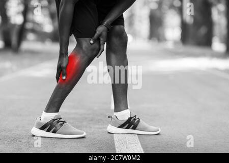 Closeup of african sportsman injured during running leg Stock Photo