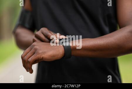 African sportsman checking on his fitness bracelet Stock Photo