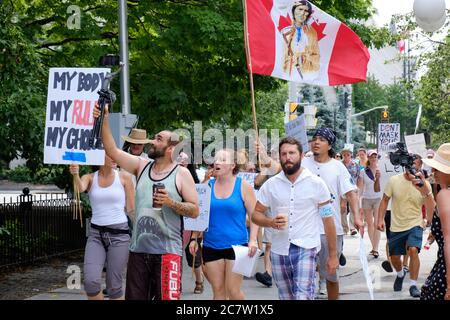 Ottawa, Canada. July 19th, 2020. Crowd of about one hundred walked from City Hall to the Canadian Parliament protesting current city bylaws requiring masks to be worn inside all public places in the city. The crowd also use to occasion to show their displeasure towards all level of government related to the imposed guidelines during the Pandemic which has to date killed more than 8800 people across the country. Stock Photo