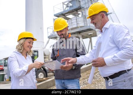 Group of construction workers discussing documents under the sunlight Stock Photo