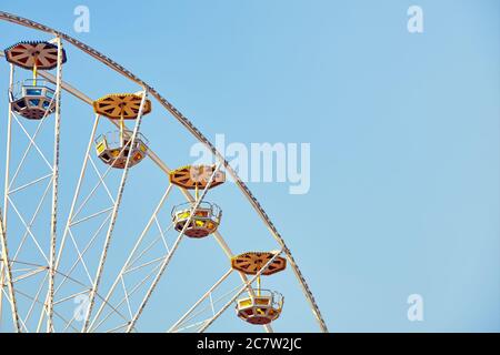 Retro toned picture of a Ferris wheel with cloudless sky, space for text. Stock Photo