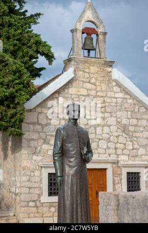 Primosten Croatia July 2020 Statue of a bishop in front of a small old christan church in the town of Primosten Stock Photo