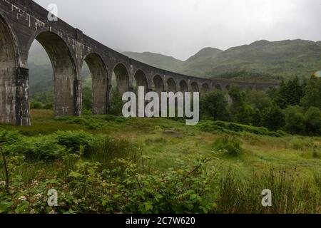 Glenfinnan, Scotland, UK. Spectators wait to photograph the Jacobite Steam Train, the Hogwarts Express, at the Glenfinnan Viaduct Stock Photo