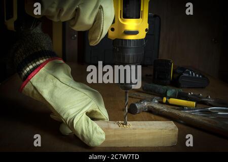 A closeup shot of a person drilling through the piece of wood Stock Photo
