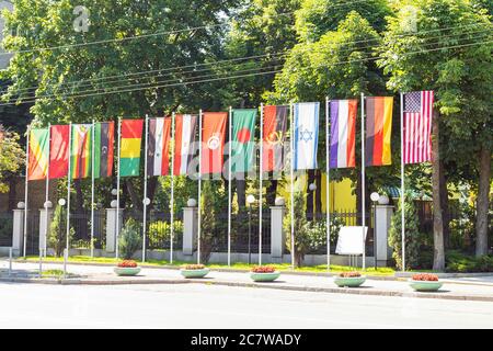 State flags of different countries on flagpole in a row waving in the wind. Diplomacy concept, international relations Stock Photo