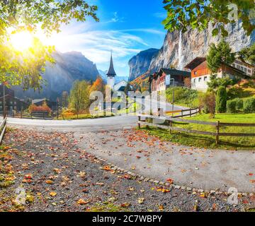 Gorgeous autumn landscape of  alpine village Lauterbrunnen with famous church and Staubbach waterfall. Location: Lauterbrunnen village, Berner Oberlan Stock Photo