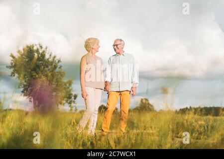 Senior husband and wife having a walk in summer landscape Stock Photo