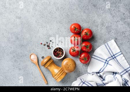 Tomatoes and spices for cooking on grey concrete background. Fresh cooking ingredients. Recipe, food background, menu concept Stock Photo
