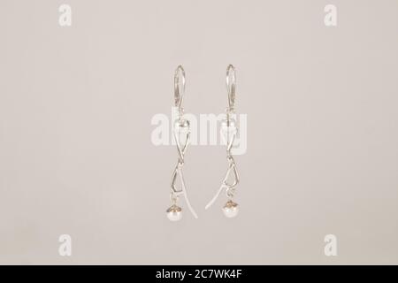 two beautiful silver earrings on white backdrop Stock Photo