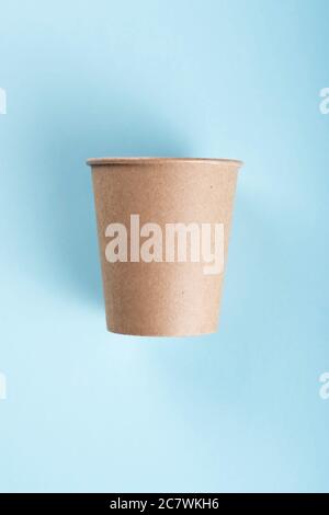 Brown coffee cup isolated on light blue background.  Stock Photo