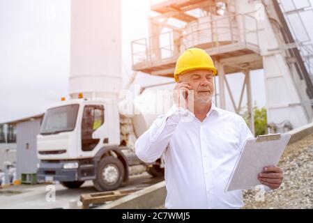 Civil engineer wearing safety helmet at the ready mix concrete plant Stock Photo