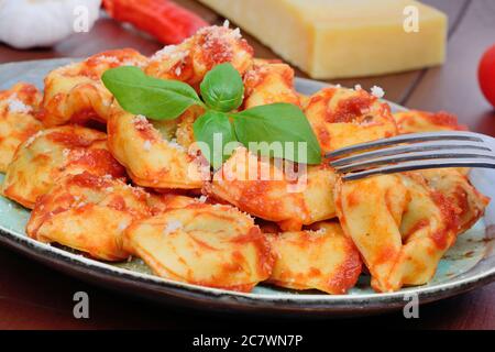 Tortellini with tomatoes sauce in a plate on table Stock Photo