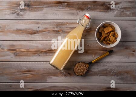 Top view homemade tradishional russian light rye kvass in bottle and crackers on wooden background. Wonderful healthy refreshing drink for summer Stock Photo