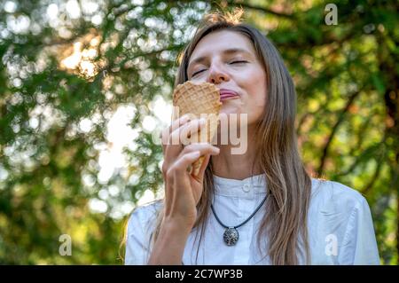 Portrait of young happy woman eating ice-cream. Cheerful young mom outdoor Stock Photo