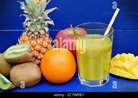 Fresh glass of juice with fruits on blue wooden table Stock Photo