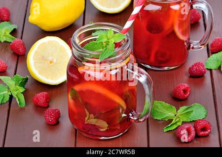 Raspberries lemonade in a jars on brown wooden table Stock Photo