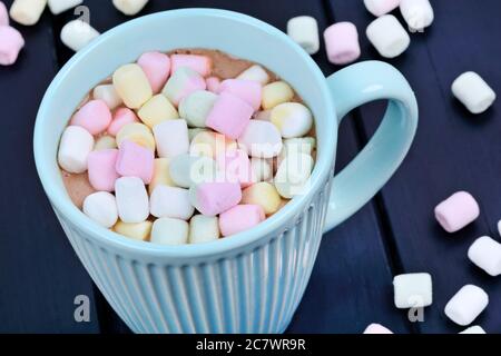 Hot chocolate with colorful marshmallows in a cup on a black wood table Stock Photo