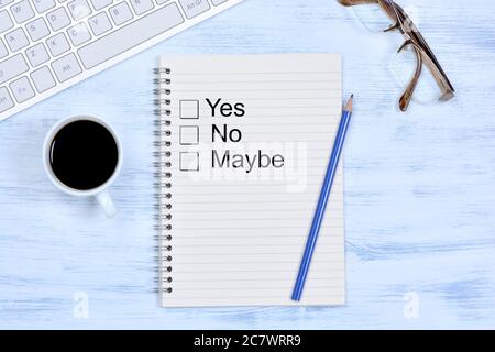 Yes No Maybe on notebook on a wooden table Stock Photo