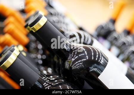 Wine bottles in a row, selective focus. Liquor store, red wine production concept Stock Photo