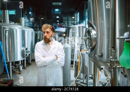 Professional caucasian technologist expert controlling industrial process in production plant. Industrial worker with uniform checking productivity Stock Photo