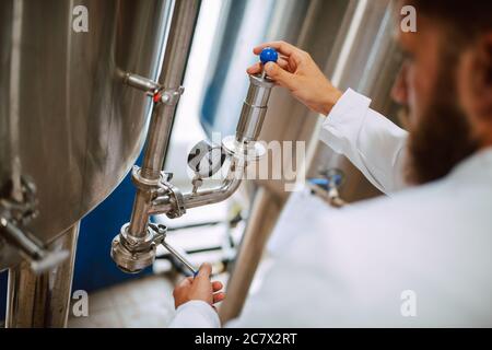 Professional caucasian technologist expert controlling industrial process in production plant. Industrial worker with uniform checking productivity Stock Photo