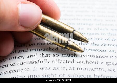 Rifle bullet model on an old book page Stock Photo