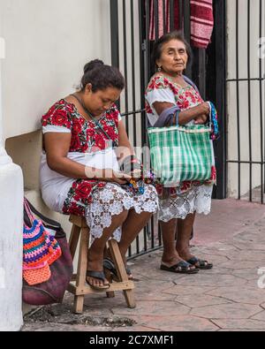 Mayan women in tradtional embroidered huipils selling handicrafts on the street in Valladolid, Yucatan, Mexico. Stock Photo