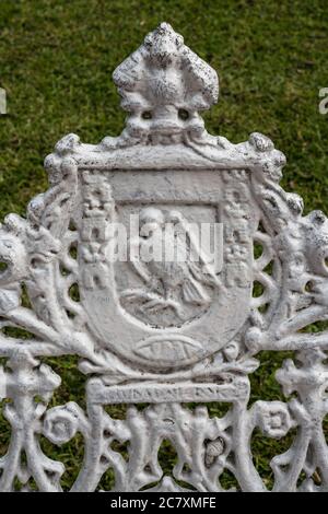 Detail of a cast iron park bench in Francisco Cantón Rosado Park.  Valladolid, Yucatan, Mexico.  On the crest is the image of a sparrow hawk Stock Photo
