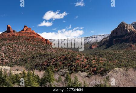 Thumb Butte and the moon rise above Sedona after an early March snowstorm. Stock Photo