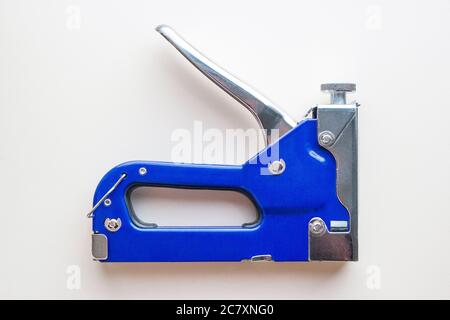 Blue industrial stapler gun, furniture industry hardware. Isolated Stock Photo