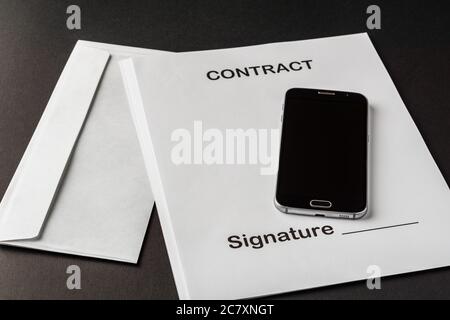 smartphone with black screen on empty contract paper and mail envelope concept of signing a business contract Stock Photo