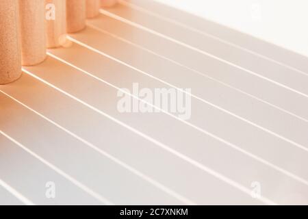 Shadows of straight lines that make an geometry light on white surface on sunny color. Stock Photo
