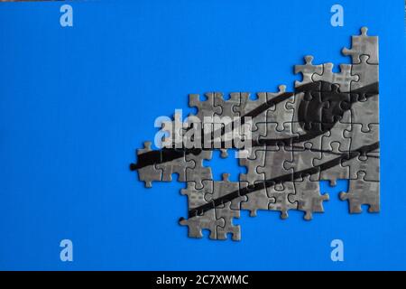 Grey half-completed puzzle on a blue background Stock Photo