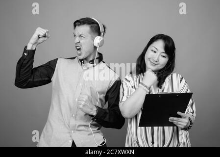 Portrait of young handsome businessman and mature Asian businesswoman together Stock Photo