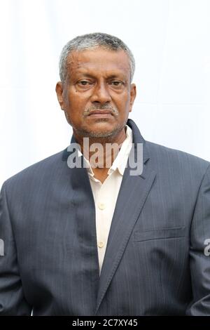 Senior Indian man cropped portrait view with dark color suit closeup on white background. Stock Photo