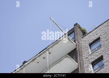 A crane is seen on roof of an old apartment building which undergoes construction work Stock Photo