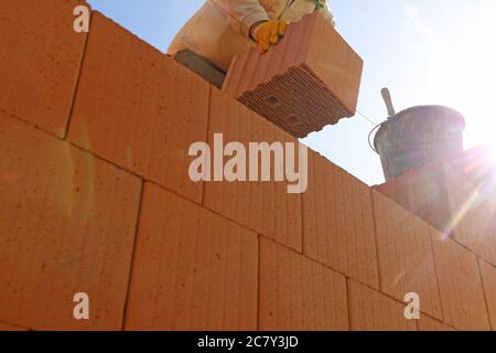 Construction worker (bricklayer) works on the construction site Stock Photo